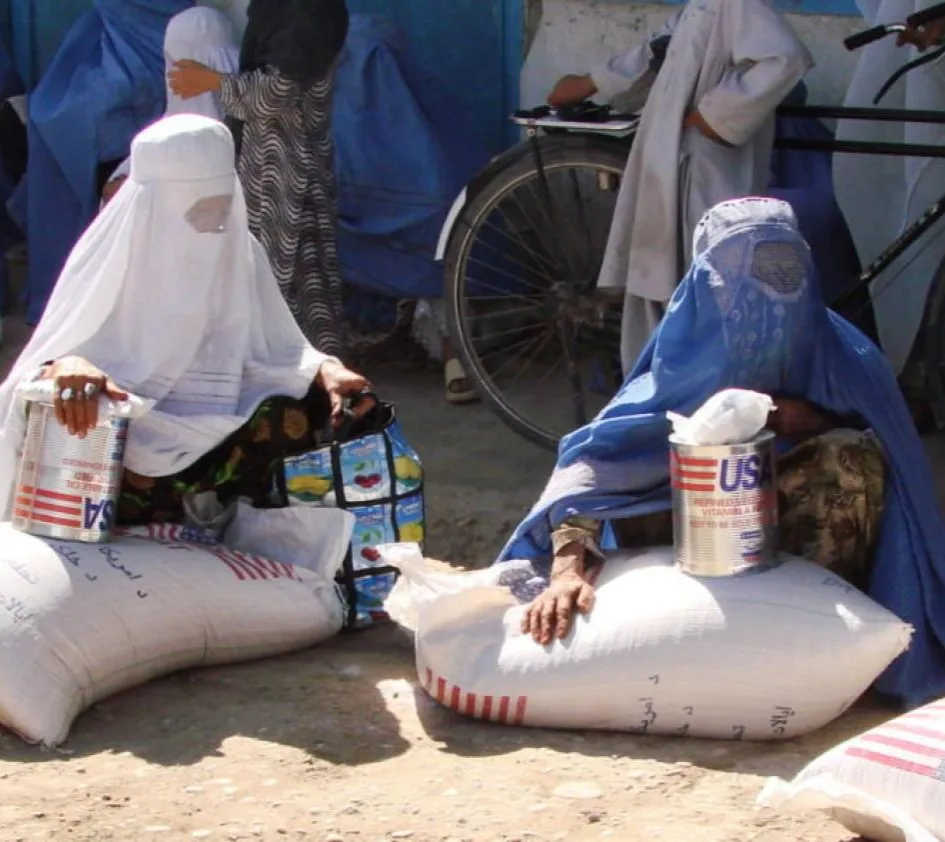 Taliban in Afghanistan: Eine Gruppe Frauen sitzt auf Nahrungsmittelsäcken