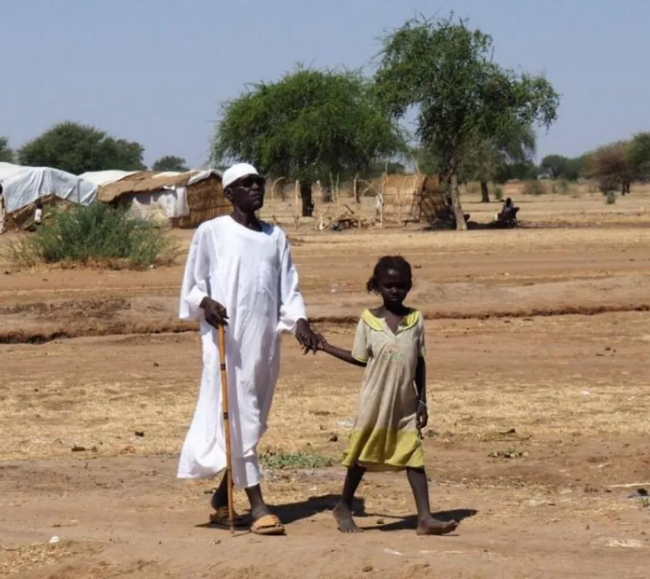 Armin mit einem Blindenstock an der Hand eines kleinen Mädchens