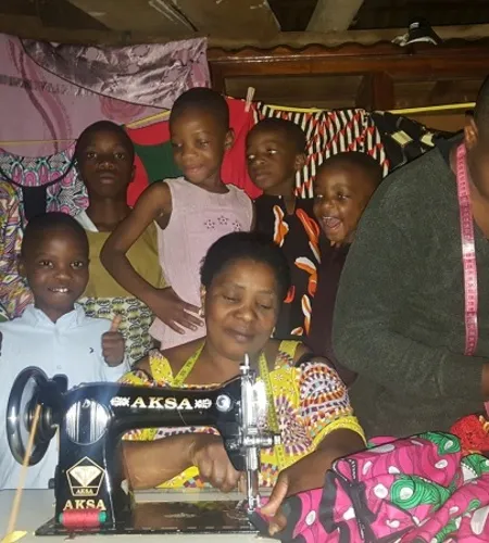 Justine bringt Mädchen das Nähen an ihrer Nähmaschine bei